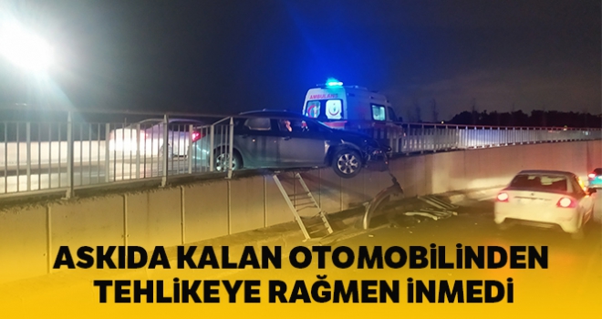 Bariyerlerde askıda kalan otomobilden düşme tehlikesine rağmen inmedi